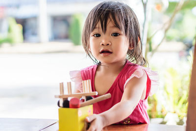 Portrait of baby girl playing with toy at home