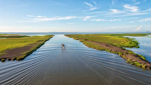 High angle view of wake in sea against blue sky