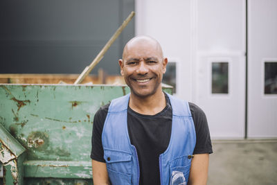 Portrait of happy bald construction worker at site