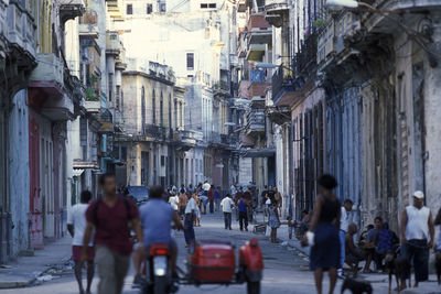 People walking on street amidst buildings in city