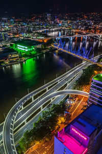 High angle view of illuminated city by river at night