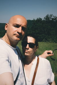 Portrait of couple against trees and sky