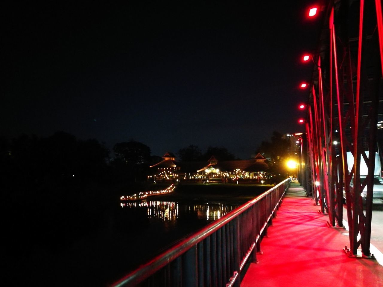 ILLUMINATED FOOTBRIDGE OVER CITY AT NIGHT