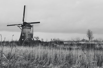 Traditional windmill on field against sky