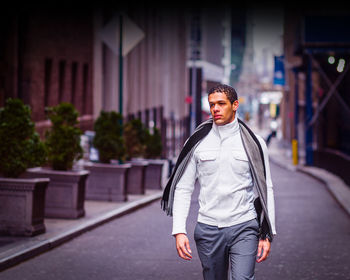 Portrait of young man walking on street in new york city in winter