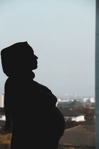 Rear view of silhouette man standing against sky