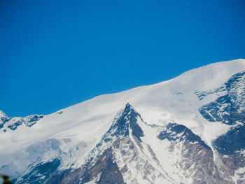 Scenic view of snowcapped mountains against clear blue sky