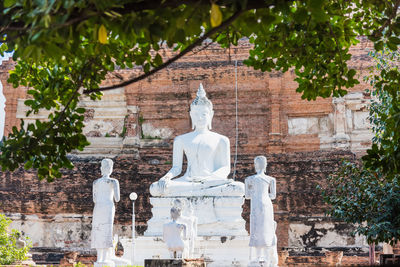 Statue against trees and building