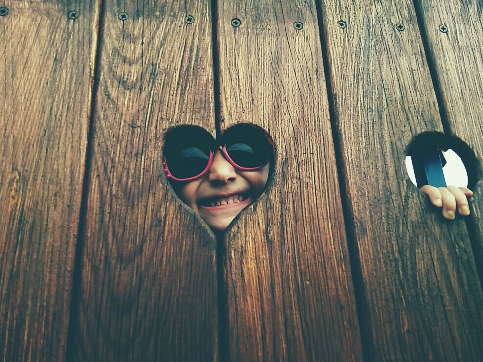 WOMAN WEARING SUNGLASSES ON WOODEN FLOOR