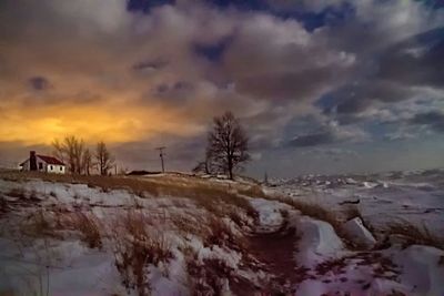 Snow covered landscape at sunset