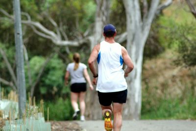Rear view of woman standing on tree trunk