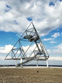 Cranes at beach against sky