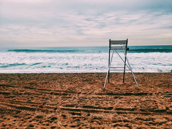 Metallic chair on sandy beach