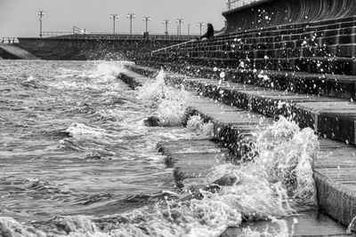 Water splashing in swimming pool against sky