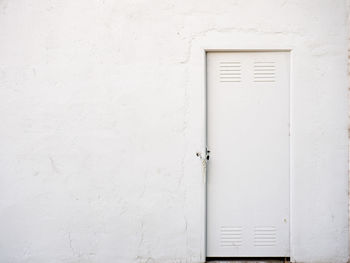 Closed door of white building