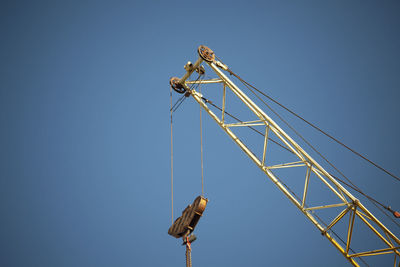 Crane. heavy machinery. hook for cargo. arrow to hold cable. steel rope.