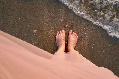 Low section of person standing on beach