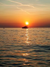 Silhouette boat in sea against sky during sunset