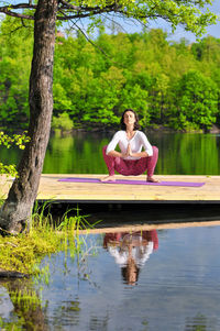 Woman doing yoga by lake