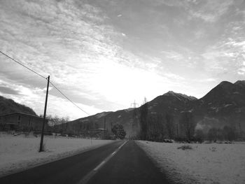 Road by mountains against sky