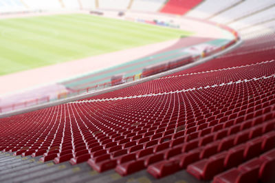 High angle view of empty red seats at soccer stadium