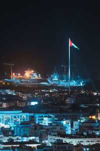 Illuminated buildings in city against sky at night