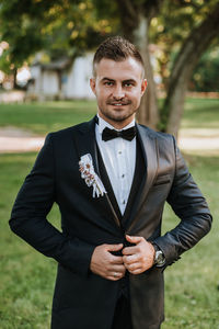 Portrait of groom standing at park