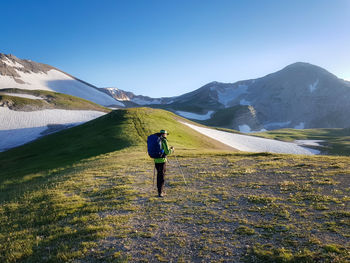 Rear view of man walking on mountain road