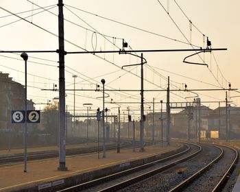 Train on railroad tracks against sky during sunset