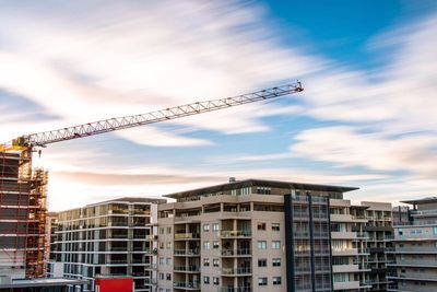 Cranes against sky in city