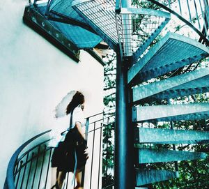 Low angle view of people walking on staircase of building