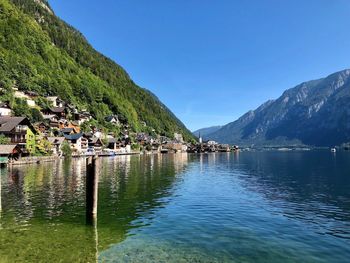 Scenic view of lake and mountains against blue sky