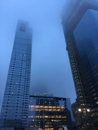 Low angle view of modern buildings against sky at dusk