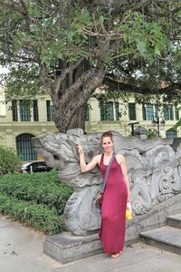 Full length portrait of woman standing by sculpture