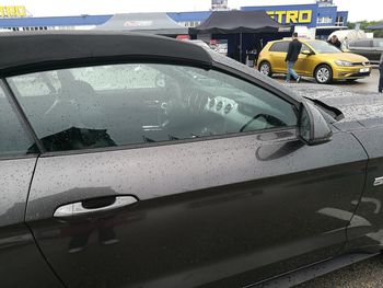 Close-up of wet car on street