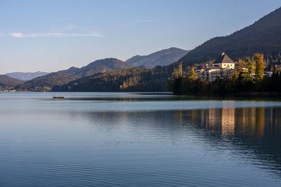 Scenic view of lake by buildings against sky