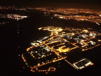 Aerial view of illuminated cityscape against sky at night