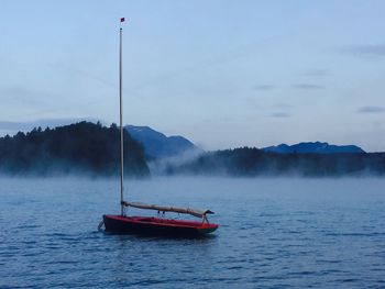 Sailboat on lake against sky