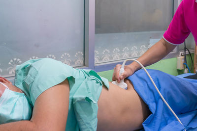 Midsection of doctor examining patient in hospital