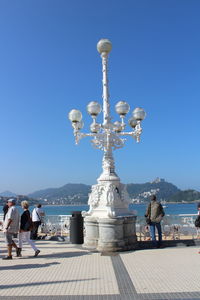 Statue of people at temple against blue sky