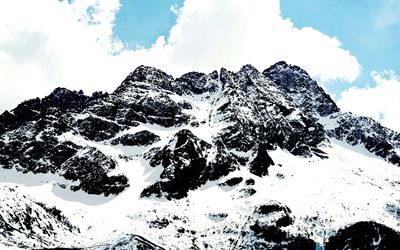 Low angle view of snowcapped mountain against sky