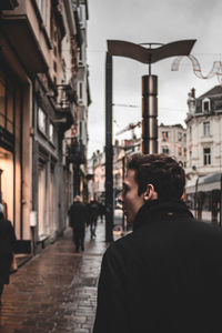 Rear view of man standing on street in city