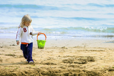 Full length of girl playing on beach