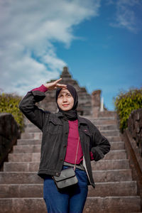 Portrait of happy girl standing against sky