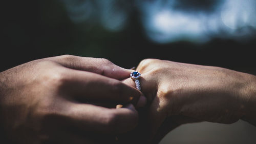 Close-up of cropped man hand putting ring in woman finger