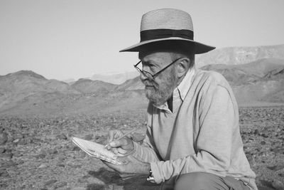 Portrait of young man standing against mountain