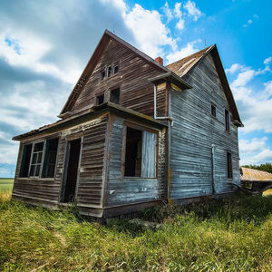 Abandoned farmhouse against blue skies