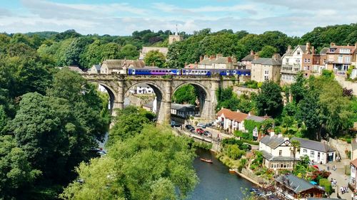 Scenic view of train over bridge against cloudy sky