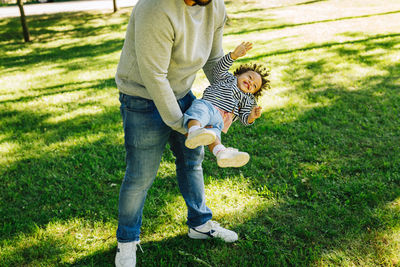 Full length of father and son on grass