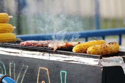 Corn on the cob and meat skewer on a charcoal grill